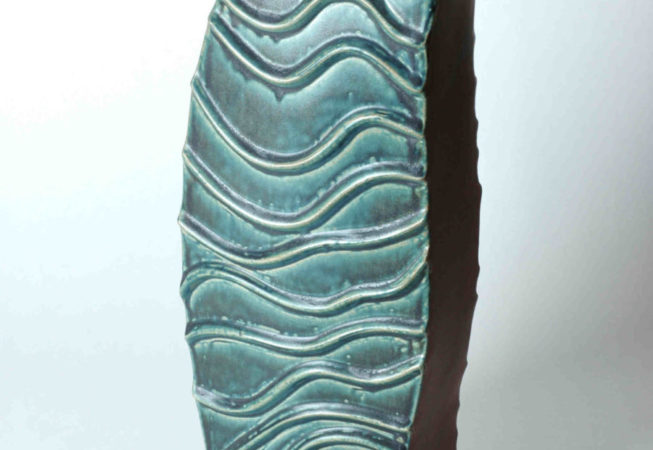 Schmale braune hohe Flächen und breite Flächen mit erhabenem Wellenmuster bilden eine schlanke rechteckige Vase. Das Unikat eignet sich für Gestecke mit Blumen oder Ästen.