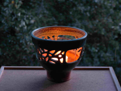 Windlicht im Dunklen mit einer brennenden Kerze